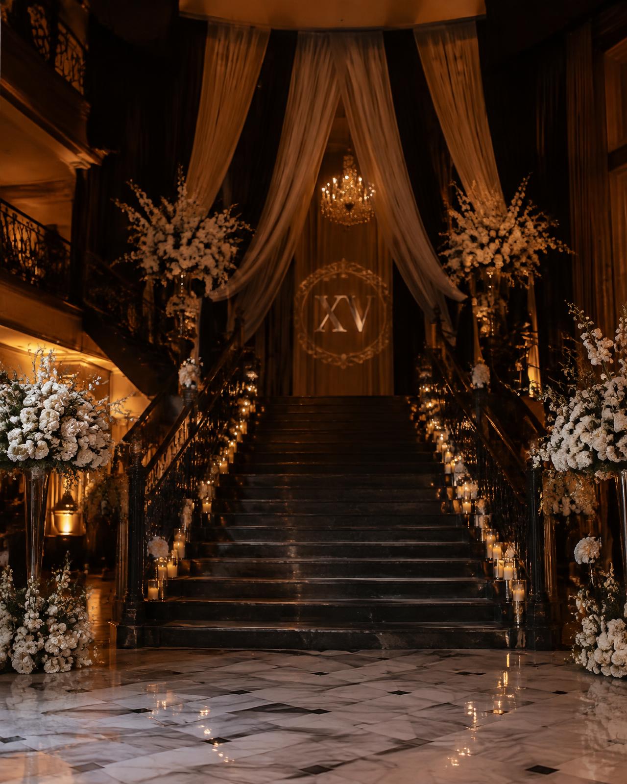 Escalinata decorada con flores blancas y velas para una fiesta de XV años